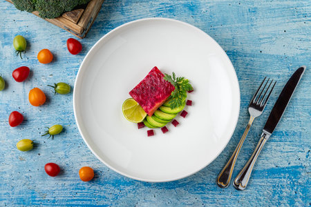 Fresh fish fillet with avocado slices, lime and beetrootの写真素材