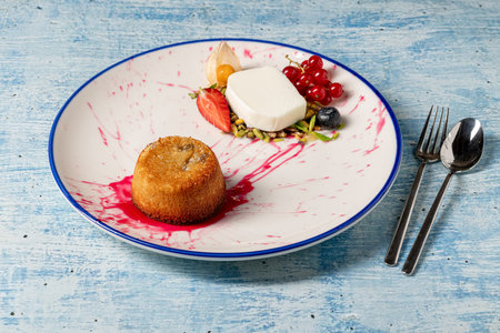 Warm tahini souffle dessert with ice cream and mixed berries on a plateの写真素材