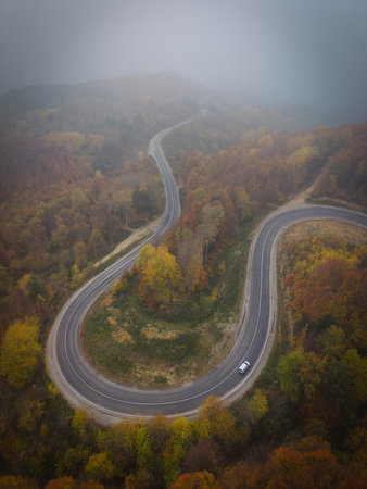 Aerial view of cars driving on the forest road between Domanic and Inegol in autumn, taken with a droneの写真素材