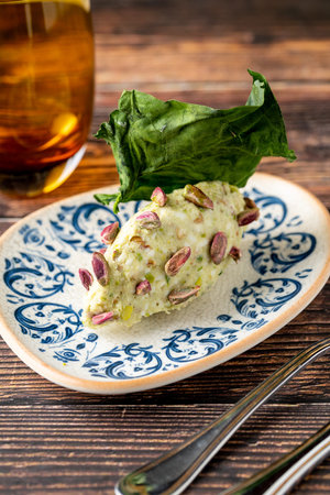 Close-up of pistachio cream dessert garnished with whole pistachiosの写真素材