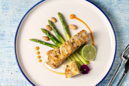 Gourmet grilled white grouper fillet served with asparagus, almond, and limeの写真素材