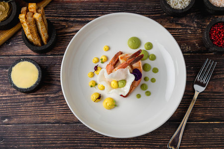 Elegant shrimp dish served with colorful sauces and edible flowersの写真素材