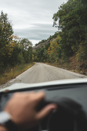 Point of view POV driving on forest road surrounded by natureの写真素材