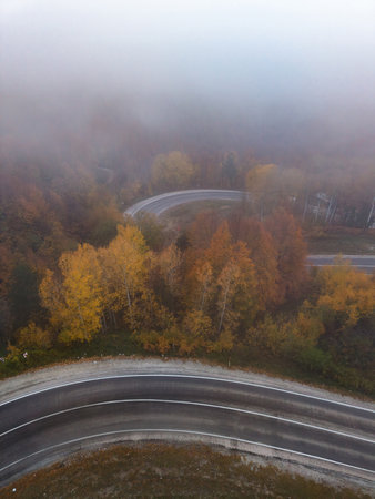 An aerial view of the winding road through a high mountain pass, passing through dense forestの写真素材