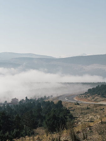 Foggy mountain landscape with winding road and atmospheric morning mood