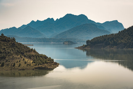Peaceful lake reflection with mountains and islands at sunset