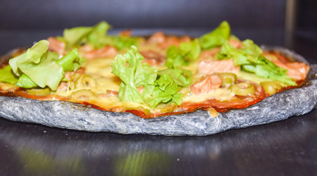 Black  Dough Pizza With Salmon on black backgroundの写真素材