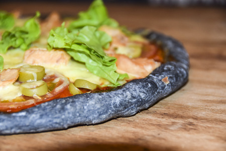 Black  Dough Pizza With Salmon on wooden backgroundの写真素材
