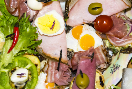 Many different Spanish tapas appetizers on a wooden background