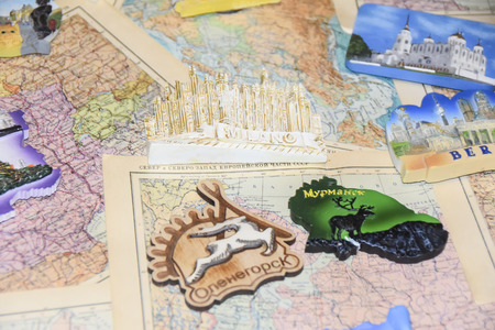 a lot of tourist souvenirs of magnets from different countries on the map designer background brightの写真素材