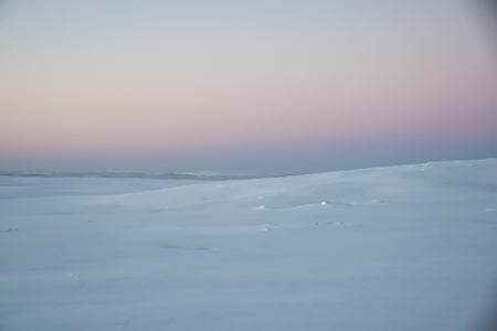 pink dawn in the tundra everywhere white snow nobody landscape roadの写真素材