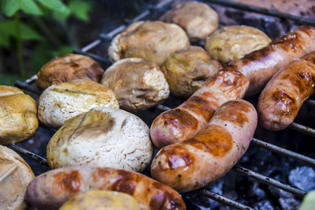 barbecue on  nature in summer mushrooms meat sausages kebab grilled over charcoalの写真素材