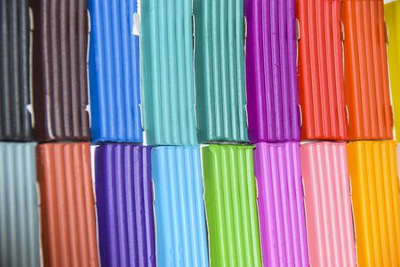 new packaging of multi-colored bright plasticine lies background