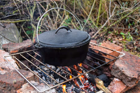 food on a hike in a cauldron green soup on an open fireの写真素材