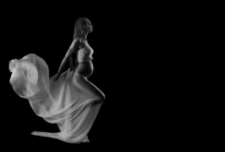 Young pregnant woman with plume on black backgroundの写真素材