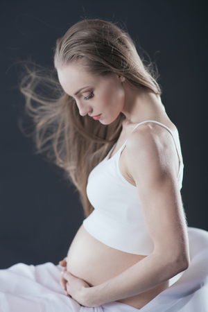 Young woman in expectation on black backgroundの写真素材