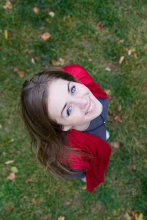Portrait of a young beautiful woman in red color scarf on grass  Top view の写真素材