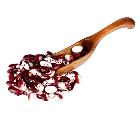 Mottled haricot legumes beans in the wooden spoon, isolated on white background.