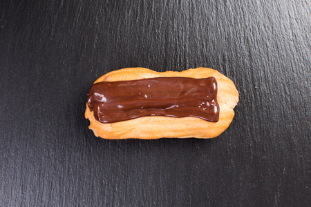 Chocolate layered eclair pastry cream custard filled on black background.の写真素材