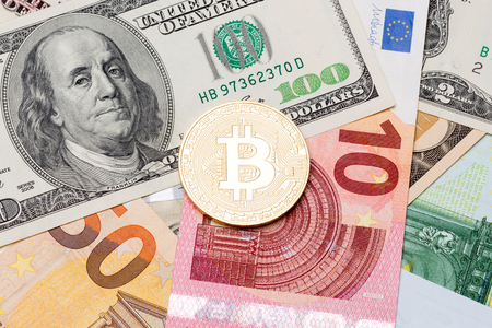 Golden bitcoins (new virtual currency) with traditional dollars and euro as a background. Macro photo.の写真素材