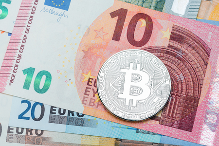 Close up of silver Bitcoin on euro currency background. Macro photo. High resolution photo.の写真素材