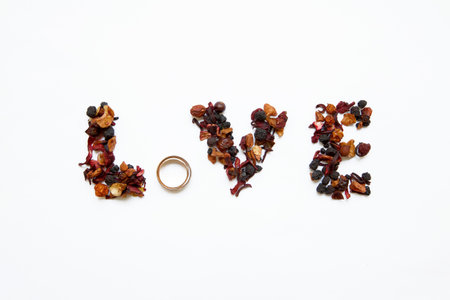 The word love written by the bride, on wedding day with the help of tea and wedding rings.