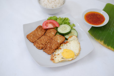 Fried pork with rice and fried egg on white plate, Thai foodの写真素材