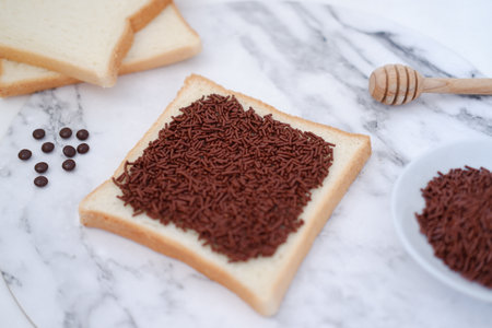 Slices of bread with chocolate sprinkles on white marble background