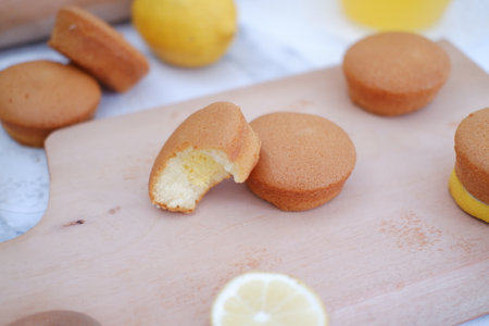Lemon cake on a wooden board with lemon slices and orange juiceの写真素材