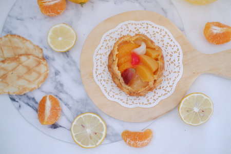 Lemon tart with orange and grapefruit on white marble table.の写真素材