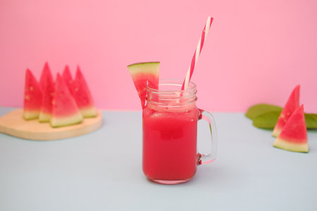Watermelon smoothie in a mason jar on a blue and pink backgroundの写真素材