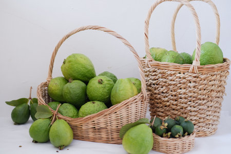Fresh guava fruit in basket and green guava on white backgroundの写真素材