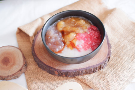 Thai dessert, Rice pudding with coconut milk and fresh fruit on wood background