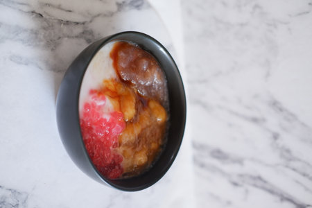 Strawberry ice cream in black cup on white marble table.の写真素材