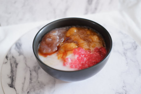 A bowl of rice porridge with fresh fruit on white marble backgroundの写真素材