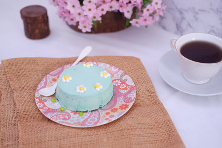 Coffee cup and cake on the table with flower background.