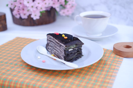 Piece of homemade chocolate crepes cake on a white plateの写真素材