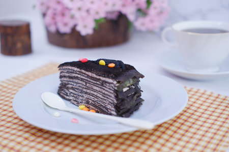 Piece of homemade chocolate crepes cake on a white plateの写真素材