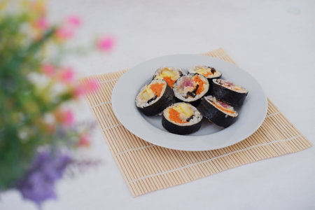 Sushi rolls on a plate with chopsticks on a white backgroundの写真素材