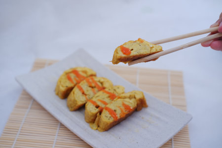 omelet with chopsticks on white plate. Selective focus.の写真素材