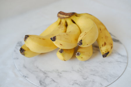 Bunch of bananas on a white marble table. Selective focus.の写真素材