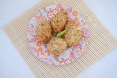 Bakwan sayur or vegetable fritter, Indonesian snack made from flour, cabbage, carrots and bean sprouts, served with chiliの写真素材