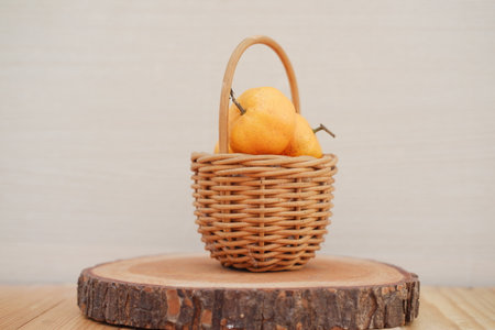 Ripe tangerines in a basket on a wooden background.の写真素材