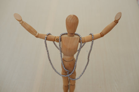 Wooden mannequin with necklaces and beads on a wooden backgroundの写真素材