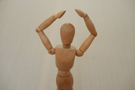 Wooden mannequin standing on a wooden background. Selective focus.の写真素材
