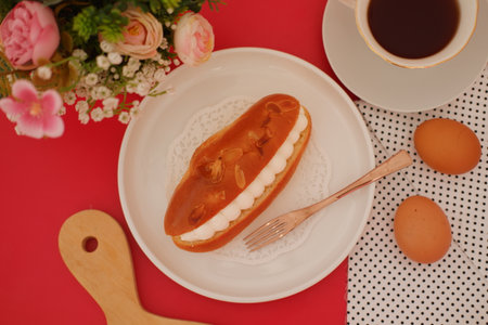 Eclair with coffee and eggs on red background, top view.