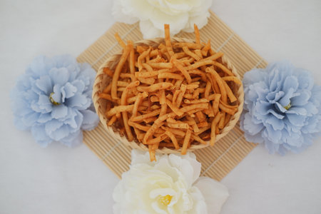potato sticks in a basket with flower on white background.