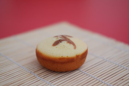 sponge cake on bamboo mat in a red backgroundの写真素材