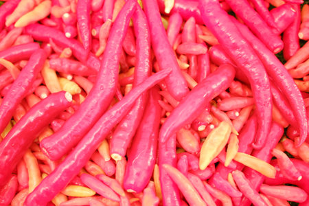 red and yellow chili peppers in a market, closeup of photoの写真素材