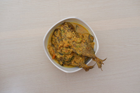 Fried fish with curry in a bowl on a wooden table.の写真素材